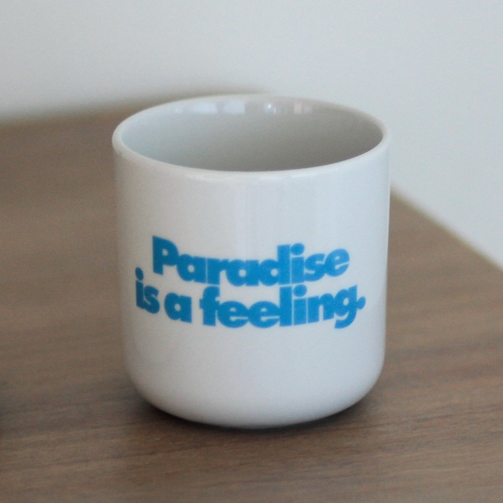 Porzellanbecher PARADISE IS A FEELING.